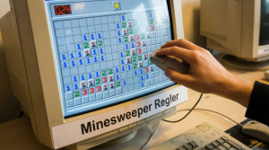 En hånd, der bruger en computermus til at spille Minesweeper og lære reglerne